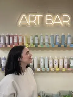 Mujer mirando botes de pintura para elegir color